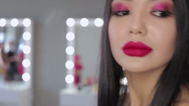 Азиатская молодая женщина с яркой помадой позирует перед камерой — стоковое видео