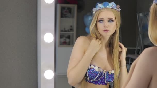 Kvinna med blont hår och blå ögon i rum med speglar — Stockvideo