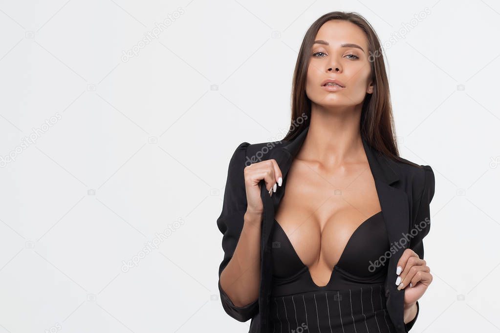 Isolated attractive sexy woman in black opened costume holding jacket and looking at camera