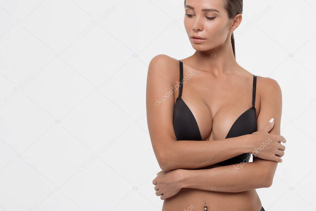 Crop view of attractive erotic young woman in lingerie crossing hands