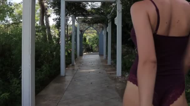 Belle fille mince en lingerie marchant dans le jardin — Video