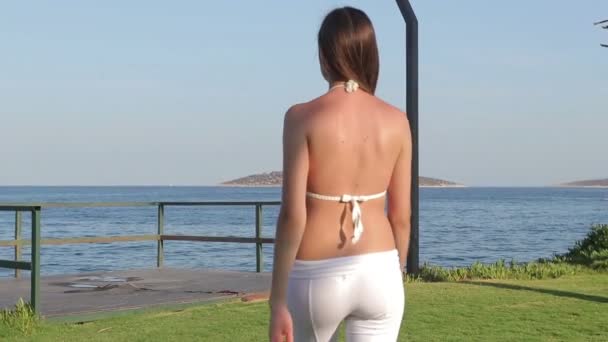 Молодая очаровательная девушка на рассвете в белых купальниках — стоковое видео