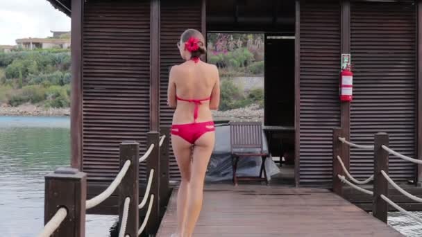 Kız adanın etrafında yürüyüş bir kırmızı mayo — Stok video