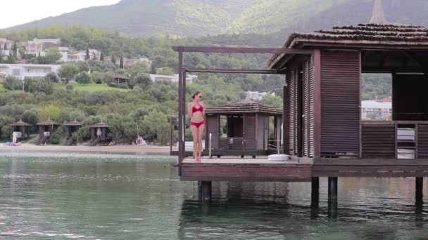 Girl in Bungalow on the water — Stock Video