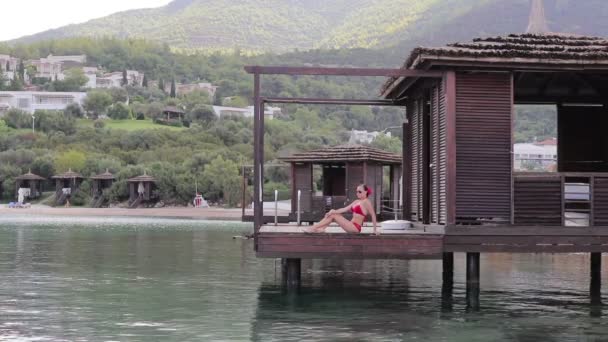 Girl in Bungalow on the water — Stock Video