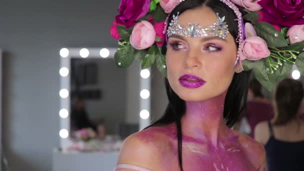 Жінка з квітами і яскравим макіяжем — стокове відео