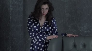 Uzun kahverengi saçlı bir ışık gri stüdyo arka plan üzerinde giyen genç güzel kadın dansçı