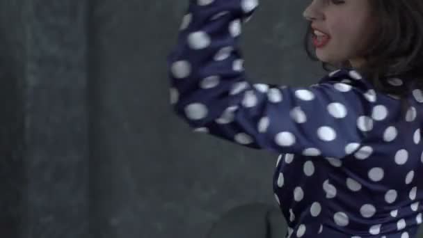 Jovem bela dançarina com cabelos castanhos compridos vestindo em um fundo de estúdio cinza claro — Vídeo de Stock