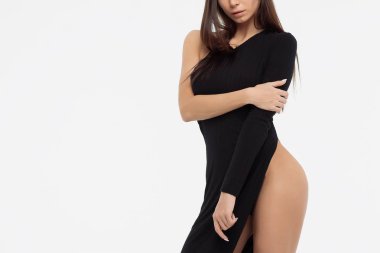 Siyah elbise şaşırtıcı ve kamera ışık gri arka plan üzerinde dururken bakarak uzun dreadlocks ile şehvetli genç erkek yan görünüm