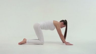 Beyaz giyimli Fitness sporcu kadın spor giyim gerçekleştiren bir bacağını yukarı kaldırarak bir egzersiz Köprüsü