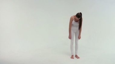 Beyaz giyimli Fitness sporcu kadın spor giyim gerçekleştiren bir bacağını yukarı kaldırarak bir egzersiz Köprüsü