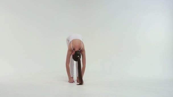 Aptidão atleta mulher está vestida de sportswear branco executa uma ponte de exercício levantando sua uma perna para cima — Vídeo de Stock