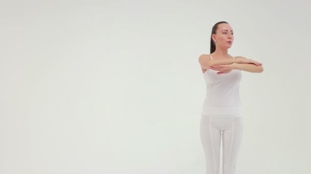 Молода чарівна спортивна жінка робить бічний міст на тренувальному килимку на білому тлі . — стокове відео