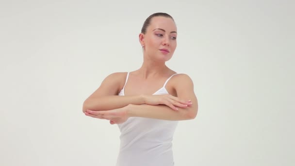 La jeune femme sportive charmante faisant le pont latéral sur le tapis d'exercice sur le fond blanc . — Video