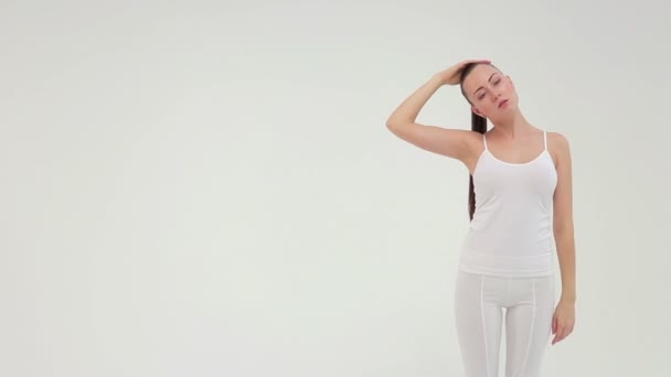 La jeune femme sportive charmante faisant le pont latéral sur le tapis d'exercice sur le fond blanc . — Video