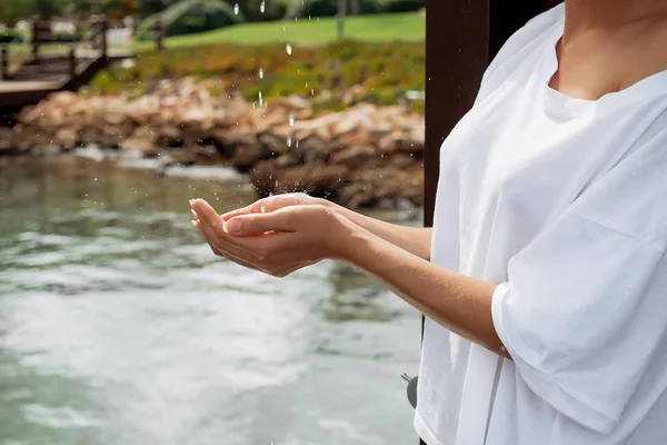 Crop woman in wet blouse avoiding water splash