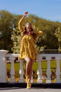 Güneşli bir günde sarı elbiseli güzel sarışın