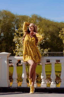 Güneşli bir günde sarı elbiseli güzel sarışın