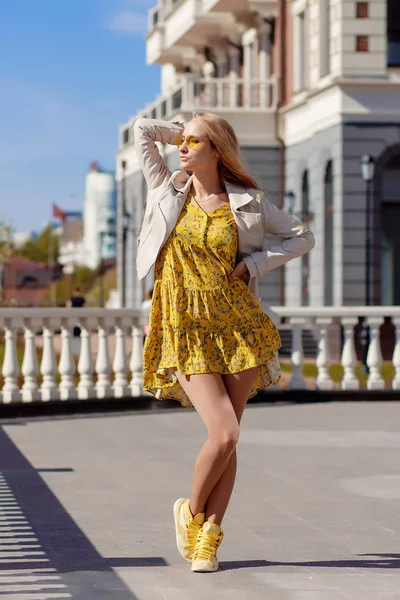 Beautiful blonde in a yellow dress on a Sunny day — Stock Photo, Image