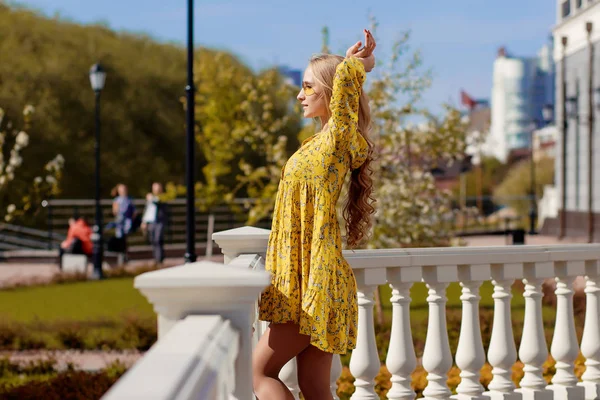 Belle blonde dans une robe jaune par une journée ensoleillée — Photo