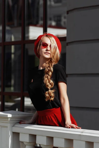 Retrato de bela jovem loira vestindo roupa preta elegante, ela sorrindo no fundo urbano — Fotografia de Stock