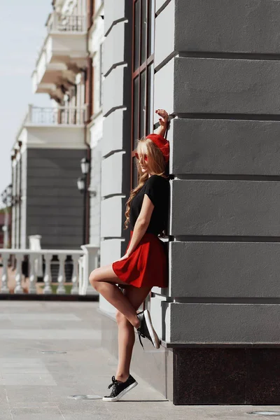 Porträt der schönen jungen blonden Frau in stylischem schwarzen Outfit, sie lächelt auf städtischem Hintergrund — Stockfoto