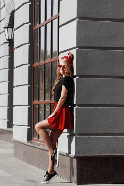 Retrato de una hermosa joven rubia vestida con un elegante atuendo negro, ella sonriendo en el fondo urbano — Foto de Stock