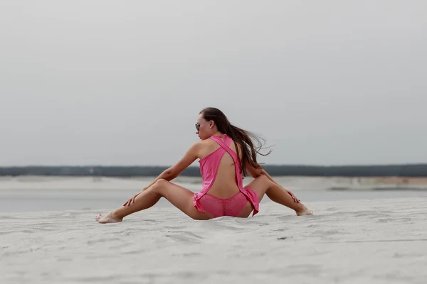 Szexi hosszú hajú nő ül lábát egymástól a tengerparton — Stock Fotó