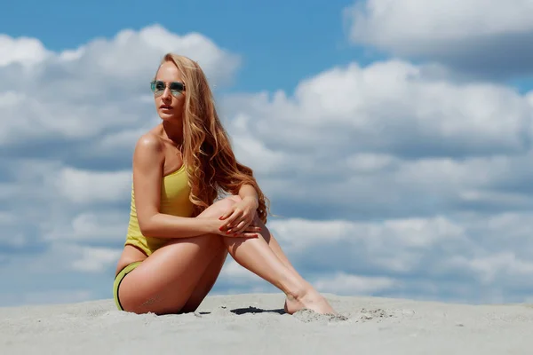 Mulher sedutora em maiô elegante ajoelhado na areia — Fotografia de Stock