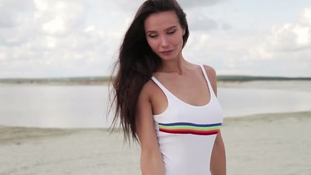 Sinnliche Frau im weißen Bikini im Stehen und Sonnenschein genießen — Stockvideo