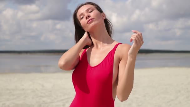 Чувственная женщина в красном бикини, стоящая и наслаждающаяся солнцем — стоковое видео