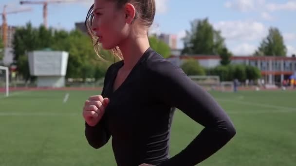 Slanke vrouw die in het stadion van de stad loopt — Stockvideo