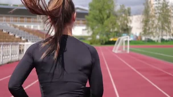 Femme mince courir sur l'hippodrome au soleil — Video