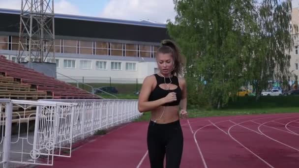 Slim svettig kvinna som kör på Athletic Field — Stockvideo