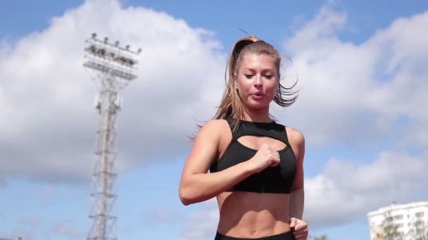 Slanke zweterige vrouw die op atletisch veld draait — Stockvideo