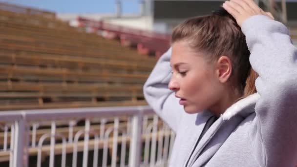 Attraktiv brunett passform flicka kom till en fitness, sport stadion utomhus. — Stockvideo
