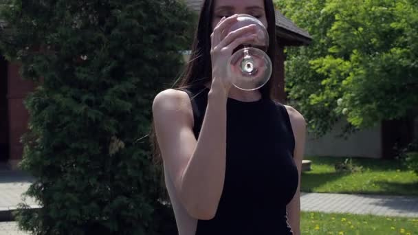 Femme élégante avec verre de vin marchant dans le jardin du manoir — Video