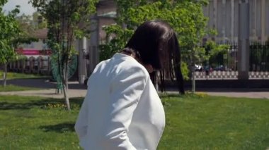 Parkta yürüyen şık bir kadın.