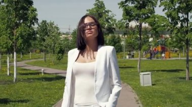Parkta yürüyen şık bir kadın.