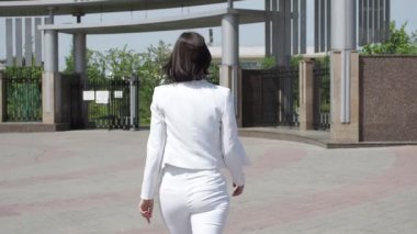 Parkta yürüyen şık bir kadın.