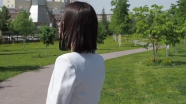 Parkta yürüyen şık bir kadın.