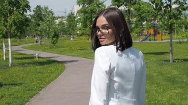 Parkta yürüyen şık bir kadın.