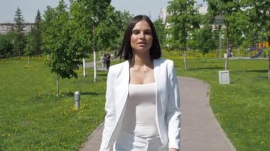 Parkta yürüyen şık bir kadın.