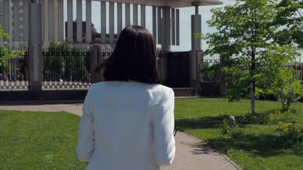 Stijlvolle vrouw loopt op pad in het park — Stockvideo