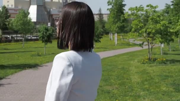 Stilvolle Frau geht im Park auf Pfad — Stockvideo