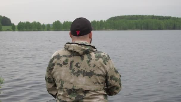 Pescatore filatura bobina di pesca. Pesca sul fiume estivo — Video Stock