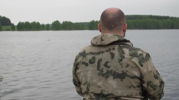 Fiskare som snurrar på fiskerullen. Fiske på sommarälven — Stockvideo