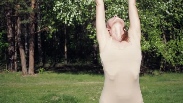 Vrouw doet yoga in het park — Stockvideo