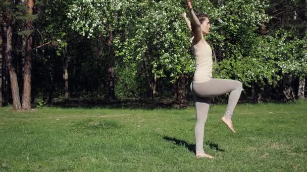 Vrouw doet yoga in het park — Stockvideo