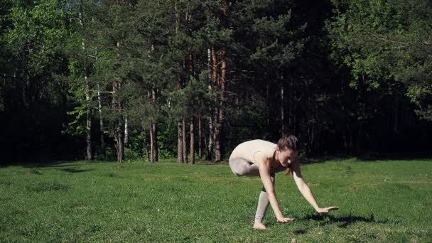 Egy nő jógázik a parkban. — Stock videók